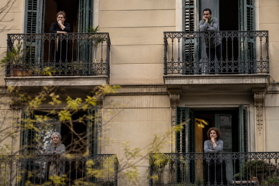 vecinos observando desde balcones en Barcelona preocupados por el aumento del alquiler