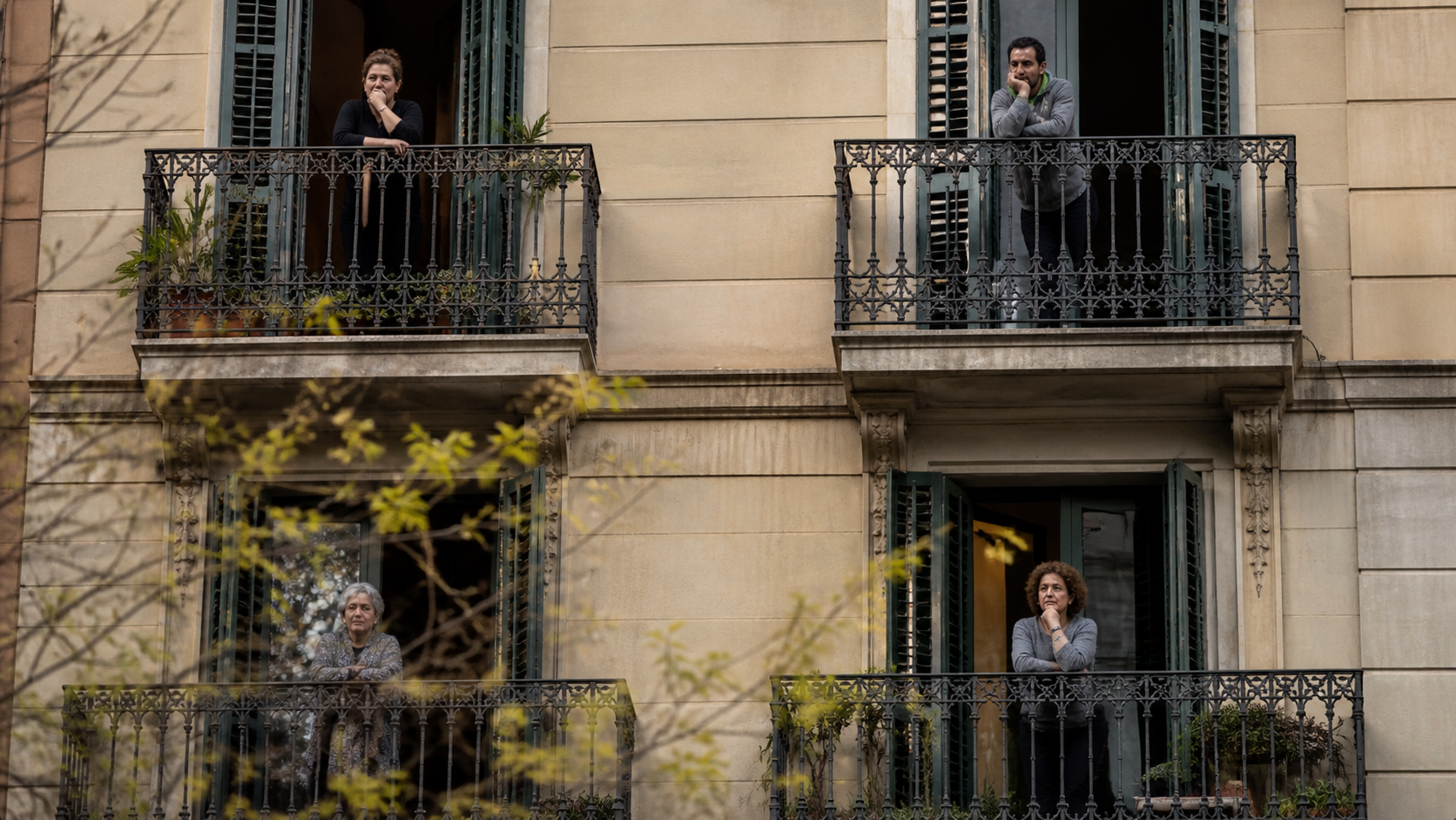 vecinos observando desde balcones en Barcelona preocupados por el aumento del alquiler