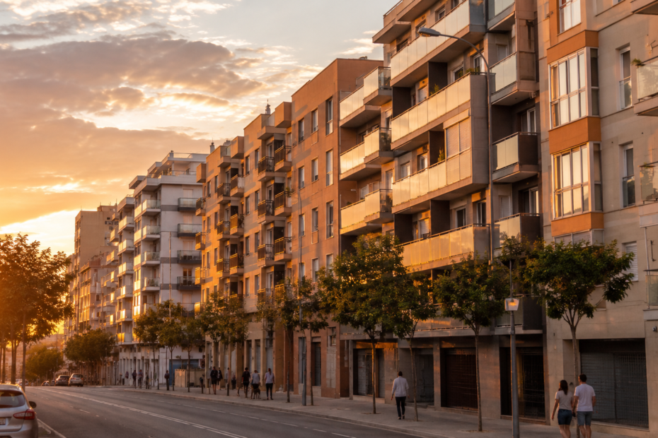 Edificios residenciales de clase media en una ciudad española durante el atardecer en una imagen relacionada con la caída de las compraventas de viviendas en España en 2026.